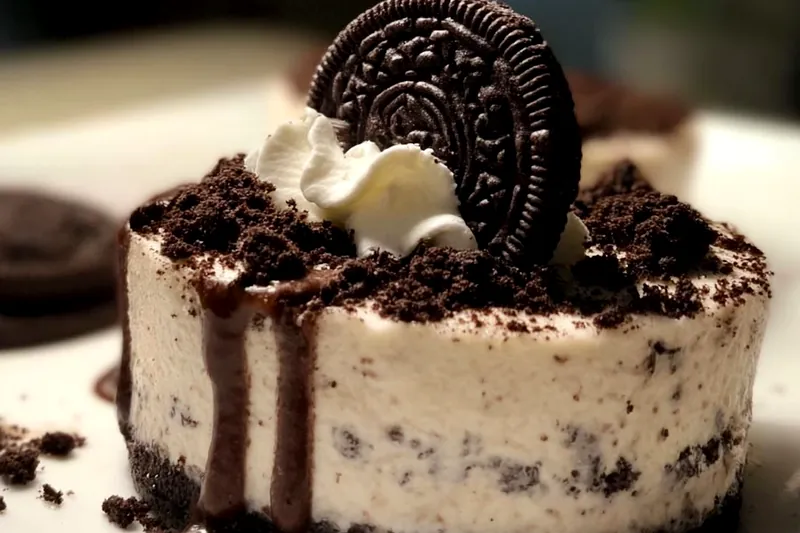 Oreo cheesecake baking in a water bath in the oven, showing the proper setup with foil-wrapped springform pan